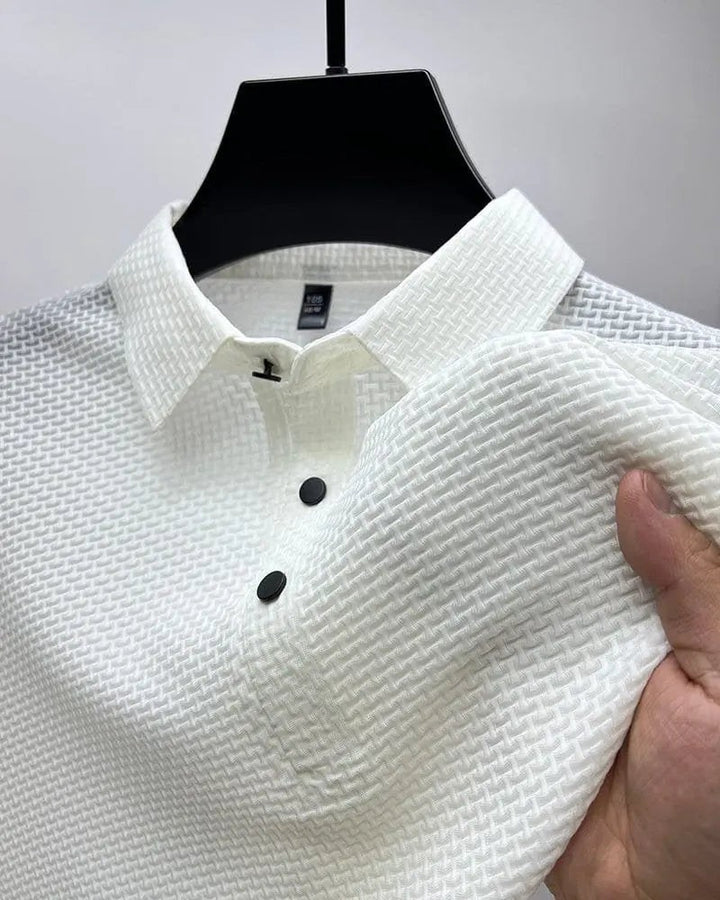 White textured knit polo shirt on hanger showing collar and buttons