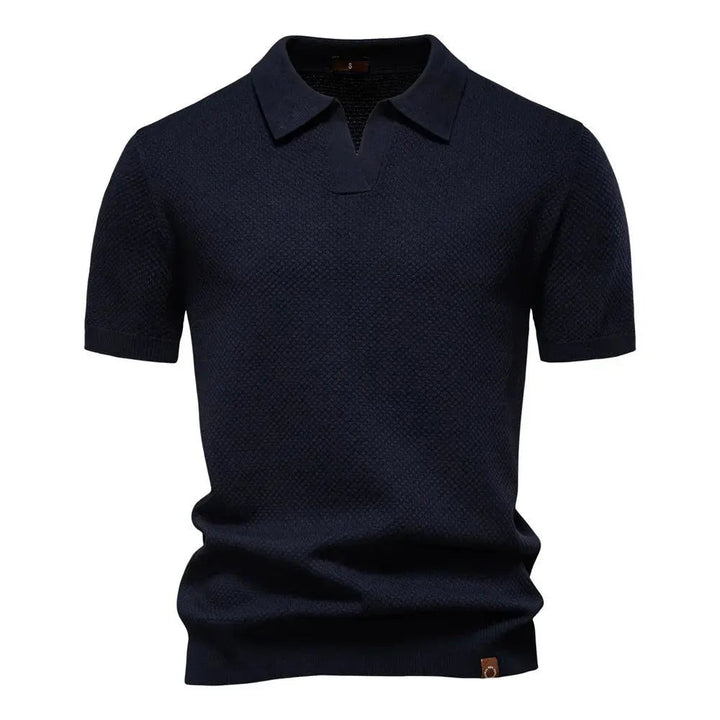 Navy blue knitted polo shirt featuring short sleeves and open collar