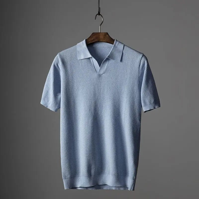 Pale blue textured knit polo shirt with short sleeves on wooden hanger