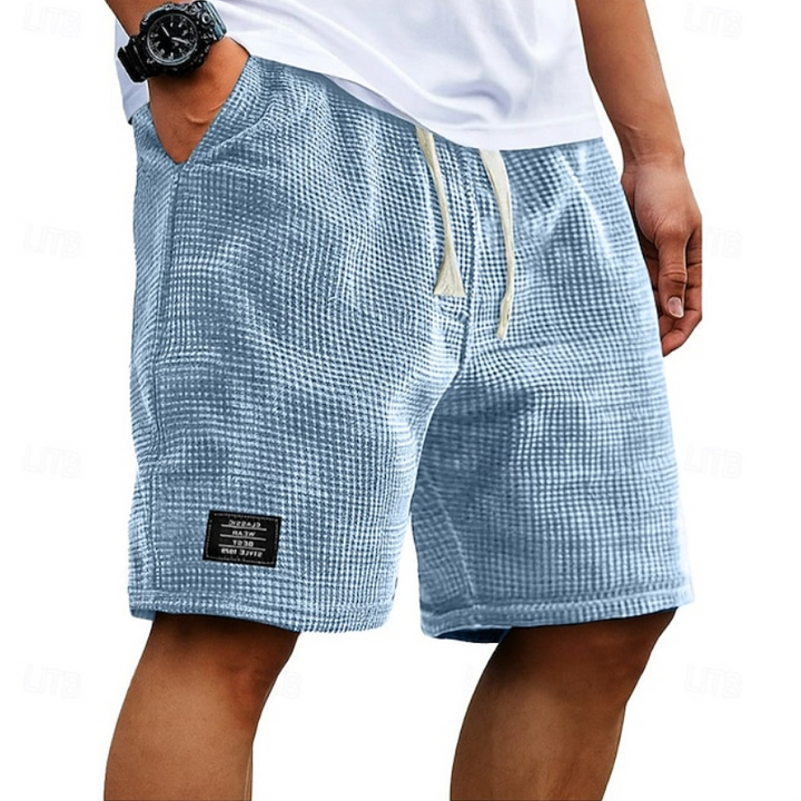 Pale blue waffle-textured shorts with cream drawcord and logo patch