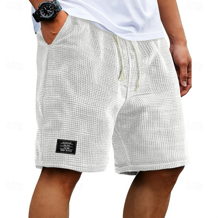White waffle-textured summer shorts with cream drawcord and branded patch