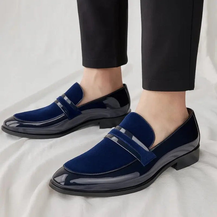 Man wearing navy suede and patent leather penny loafers with black trousers