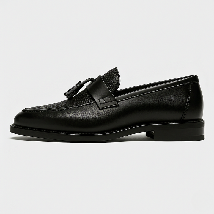 Side profile of black leather tassel loafer with saddle strap and stitched sole