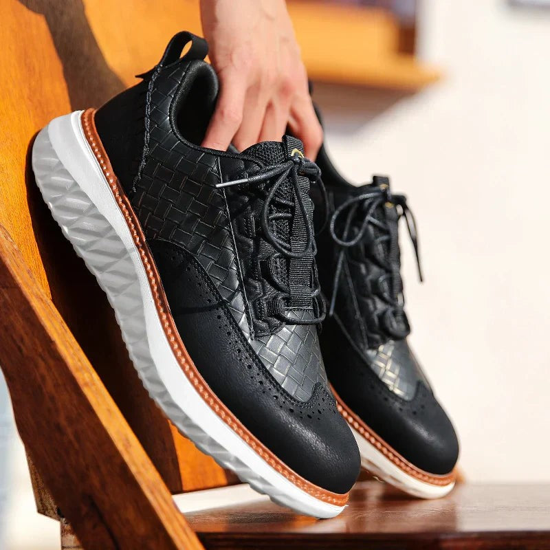 Black woven leather platform trainers held above a wooden bench, laces loose