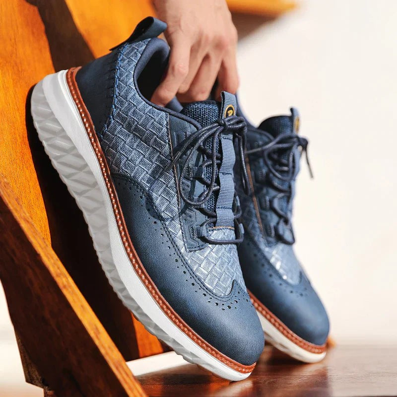 Navy leather platform trainers with woven texture held up by hand, laces untied