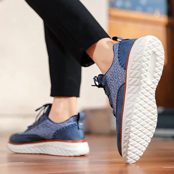 Navy woven leather trainer worn on foot, showcasing chunky white platform sole