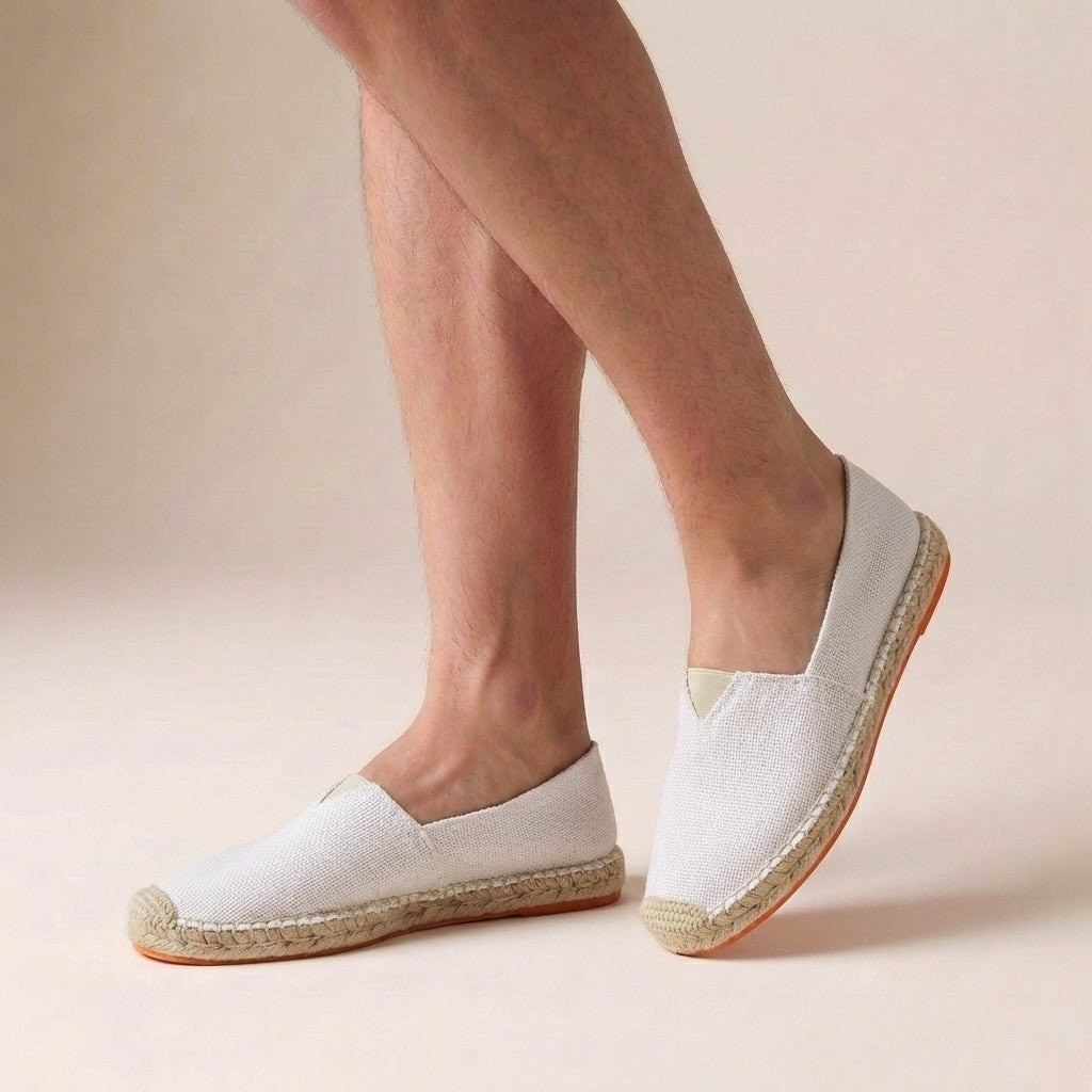 White canvas slip-on espadrilles with jute sole, worn on feet