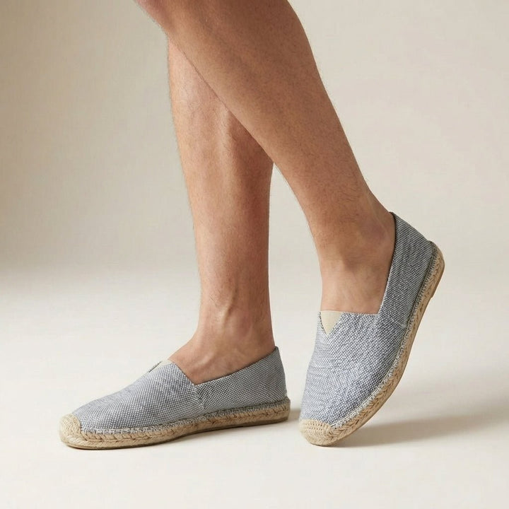 Grey speckled canvas espadrilles with braided jute edging, worn on feet