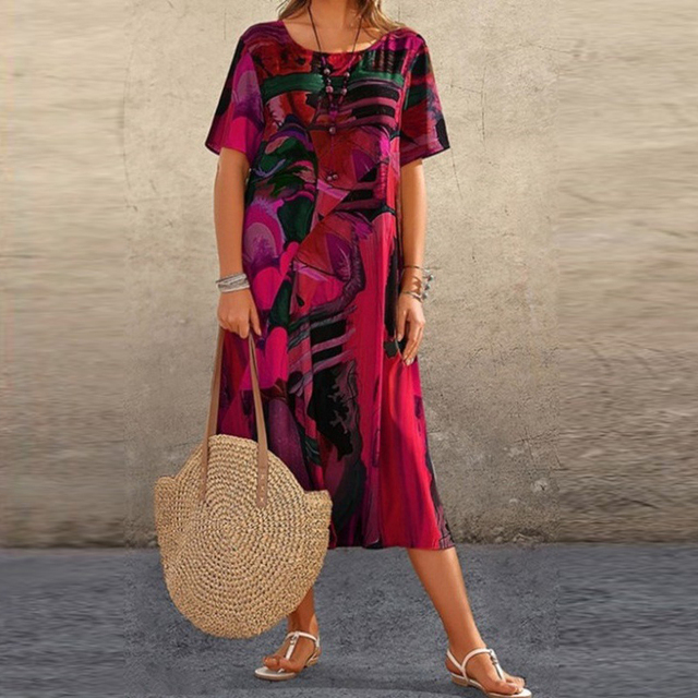 Pink and black abstract print midi dress paired with woven straw shoulder bag