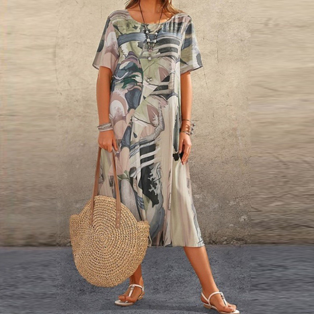 Neutral toned abstract print midi dress worn with woven straw shoulder bag