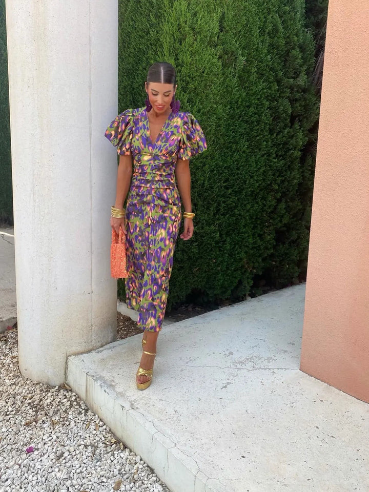 Full-length view of green and purple print midi dress paired with gold platform heels