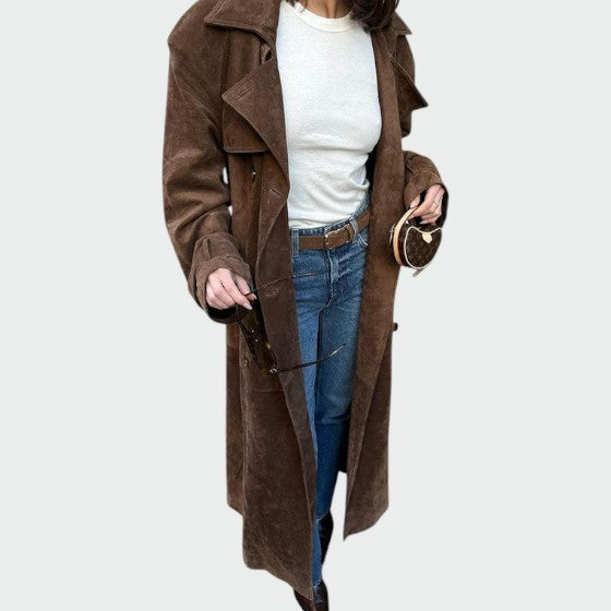 Woman styling a brown suede trench coat with jeans and a mini bag