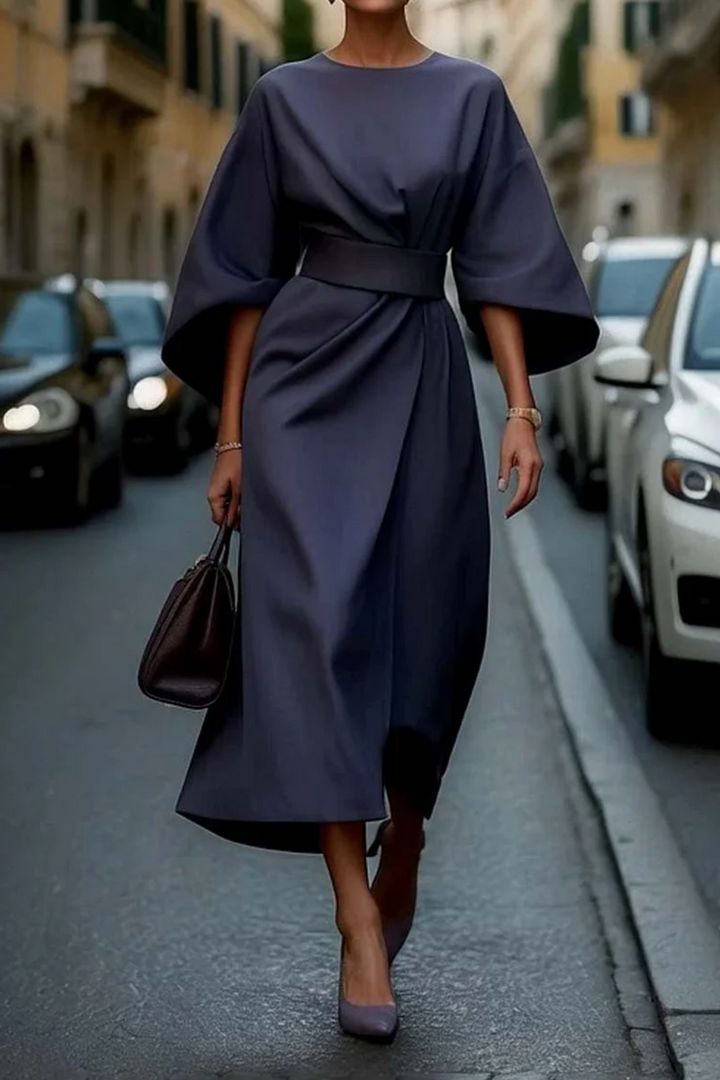 Navy lantern-sleeve midi dress cinched with a contrast belt, worn with pointed heels