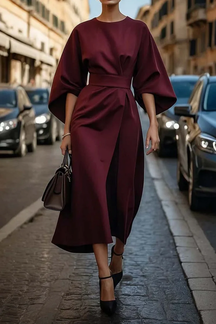 Burgundy lantern-sleeve wrap dress with a fitted waist belt and ankle-strap heels