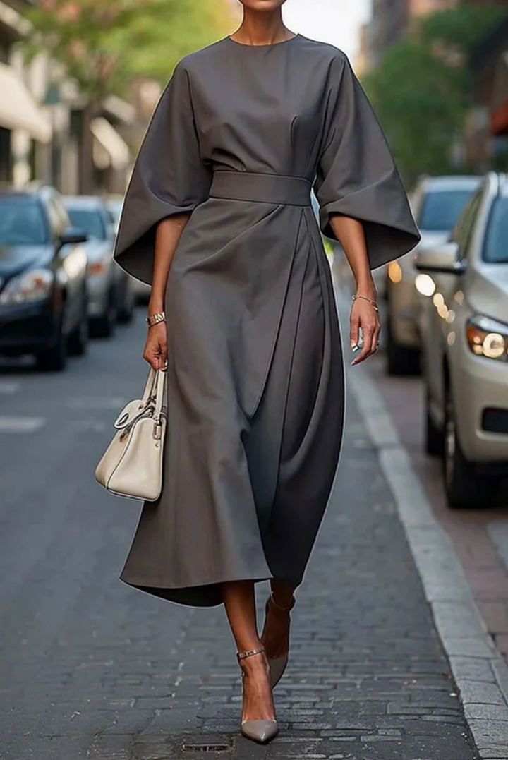 Charcoal grey lantern-sleeve midi dress with a wide belt, worn with strappy heels