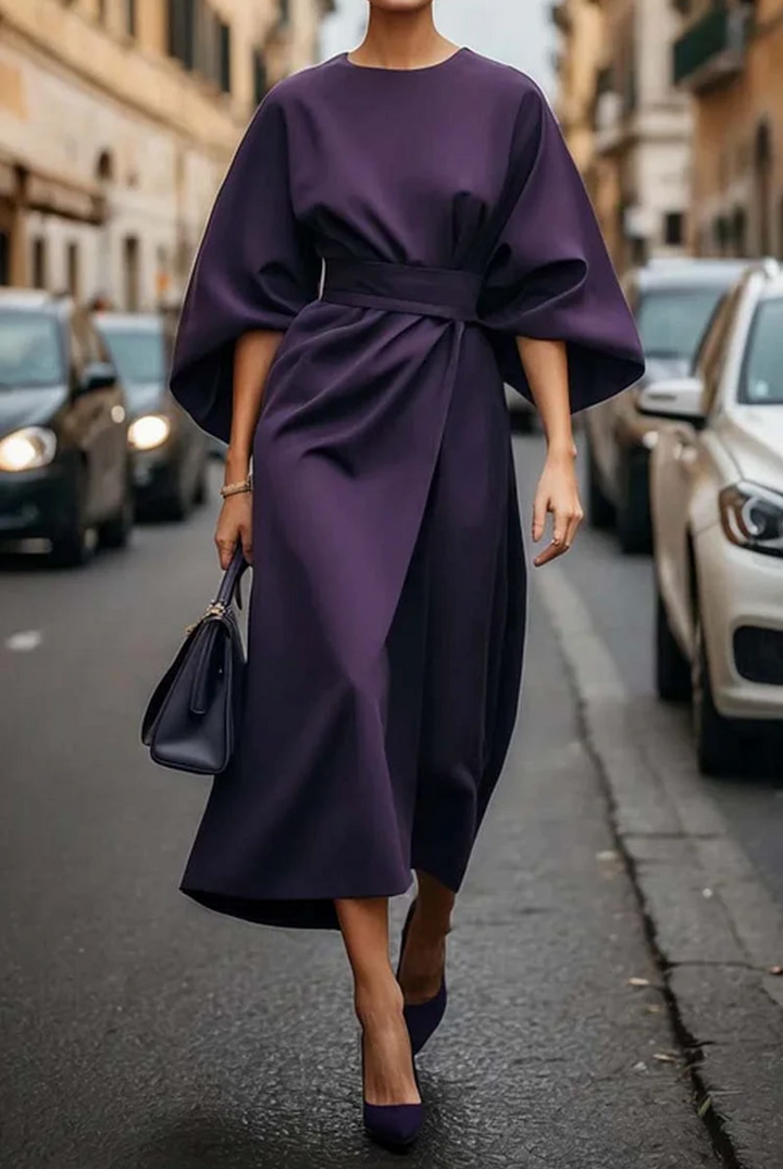 Deep purple lantern-sleeve belted midi dress styled with a leather handbag