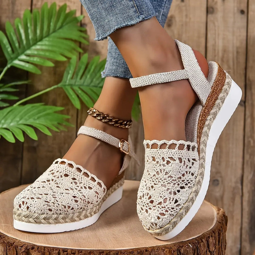 Close-up of woven cream espadrille sandal showing crossover ankle strap detail