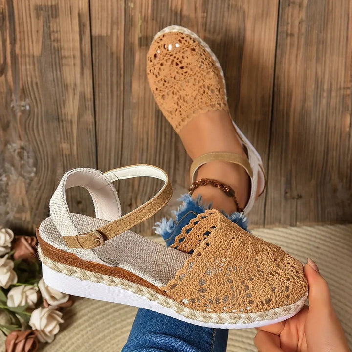 Tan crochet wedge espadrille sandal paired with cream version on wooden stool