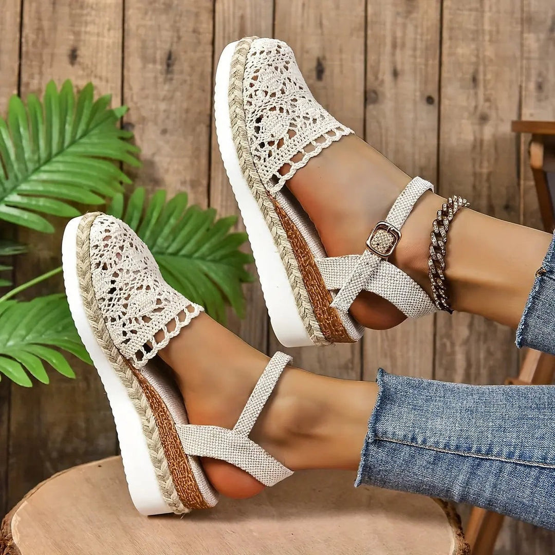 Tan crochet espadrille sandal worn with cuffed denim jeans outdoors