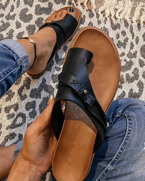 Black leather toe-post sandal with stud accents shown beside worn pair