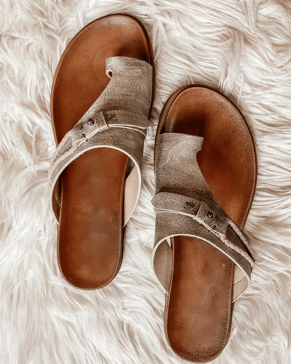 Pair of metallic bronze flat sandals with toe-post design on faux fur