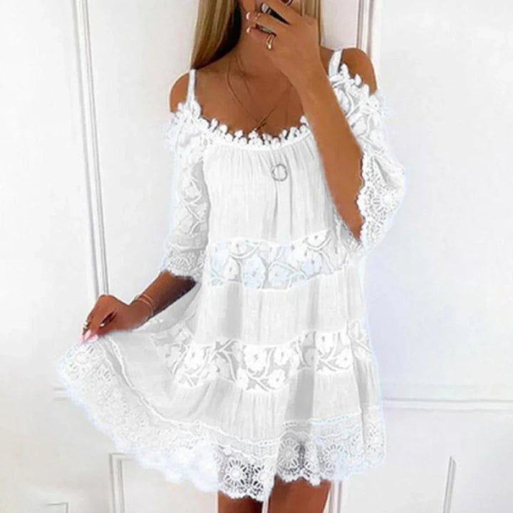 White cold-shoulder mini dress showcasing floral lace panelling and flared skirt