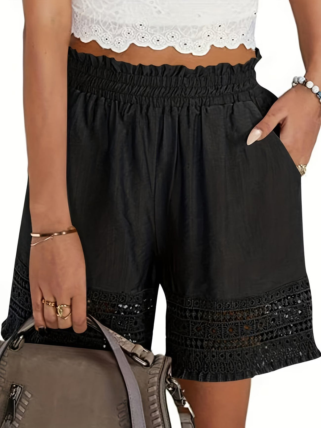 Black paperbag-waist shorts featuring crochet lace trim and slant pockets