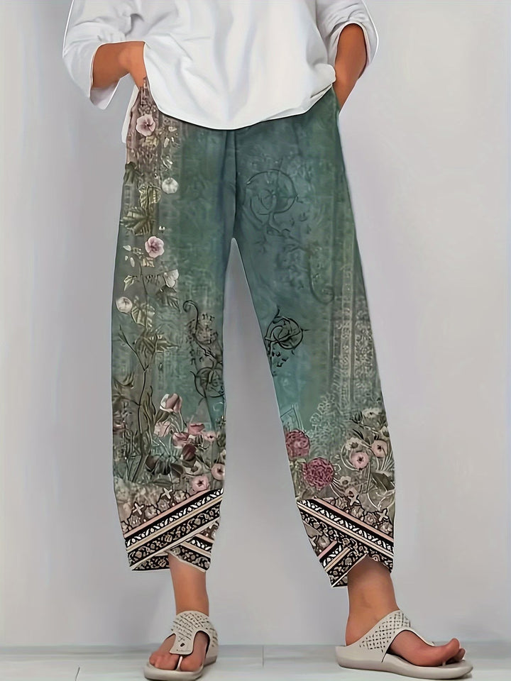 Sage green vintage floral print trousers with tribal border hem detail