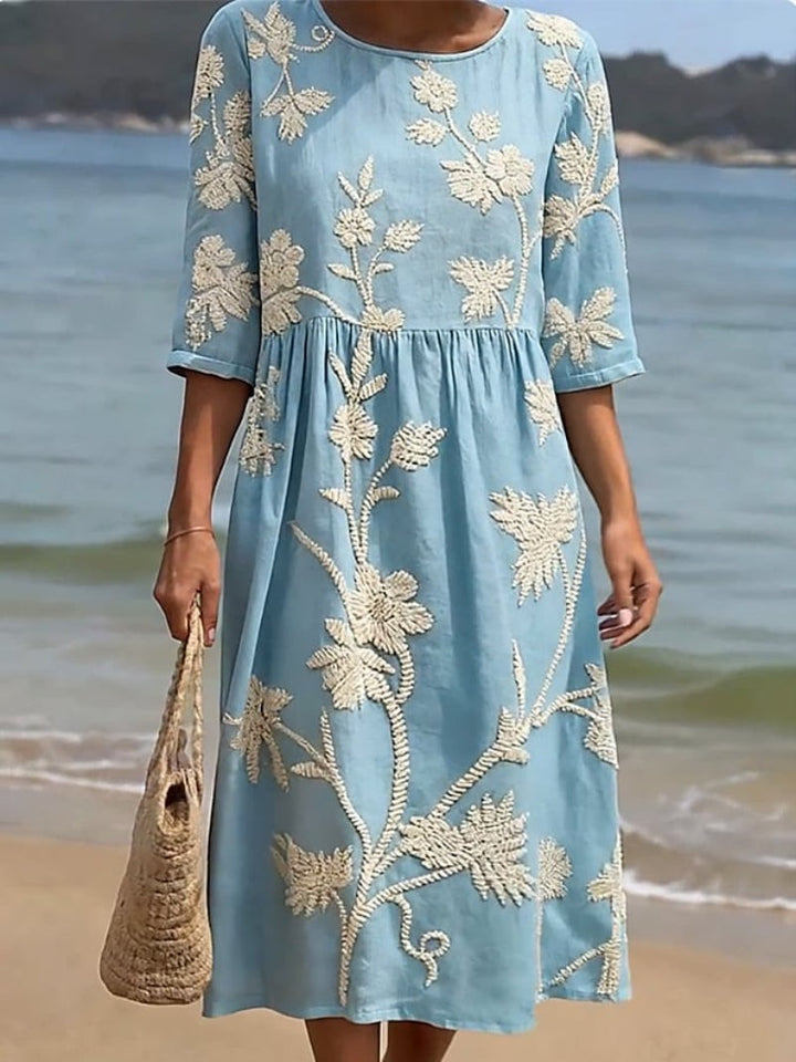Close-up of pale blue embroidered midi dress with three-quarter sleeves
