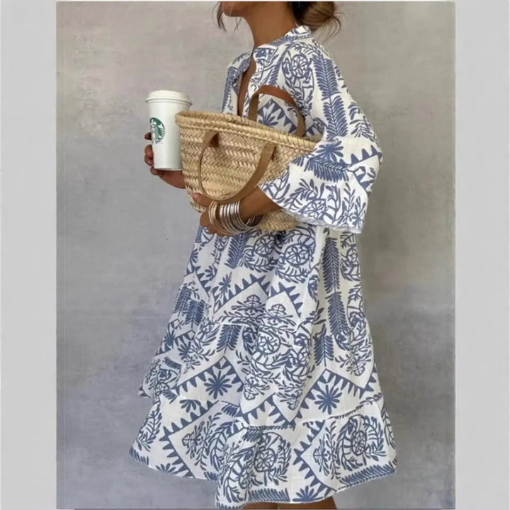 Blue and white paisley print tunic dress with flared sleeves and straw tote