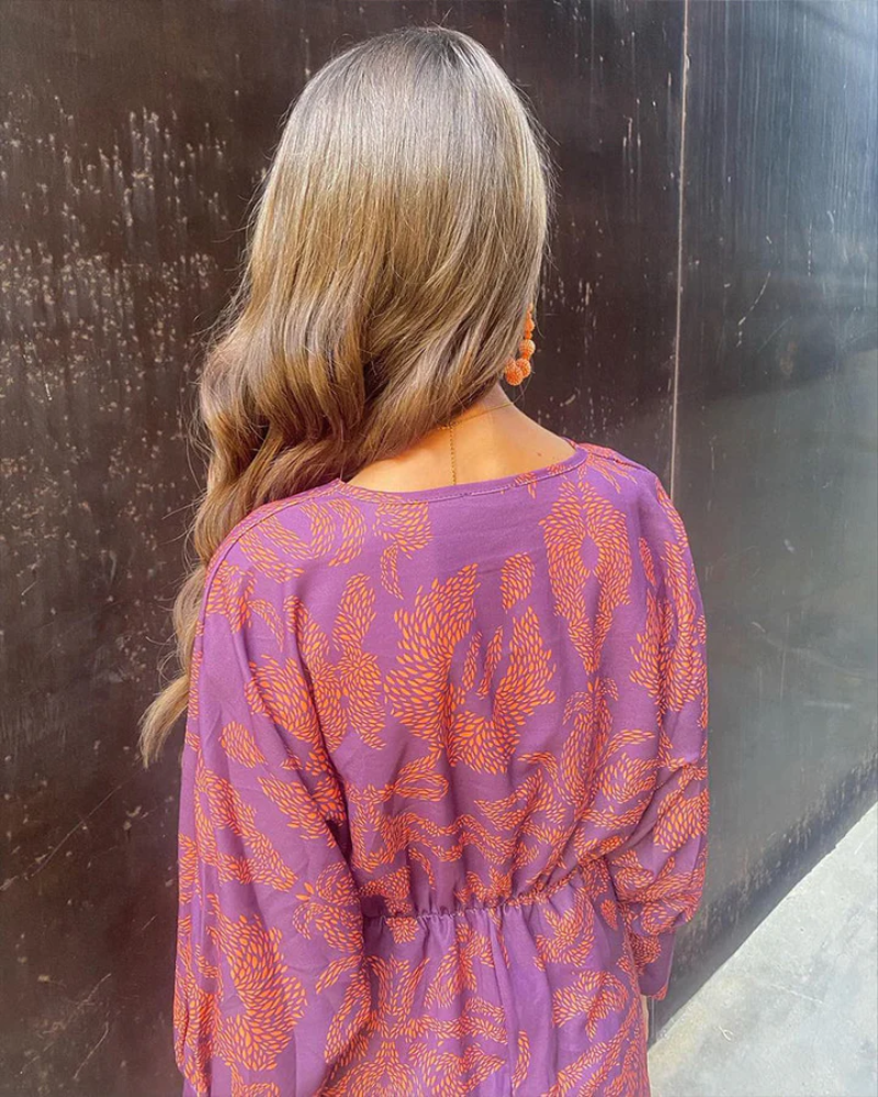 Rear view of purple maxi dress with orange print and elasticated waistline