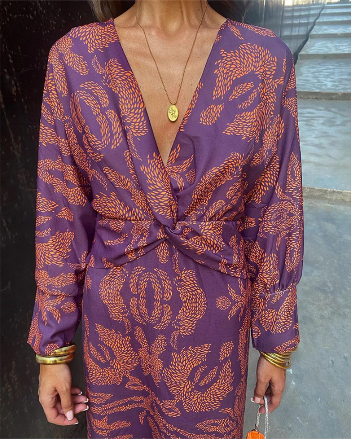Close-up of purple maxi dress showing orange paisley print and twisted waist tie