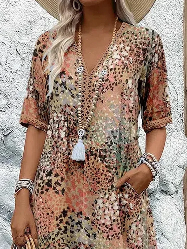 Close-up of crochet-trimmed V-neck on multicoloured patchwork print midi dress