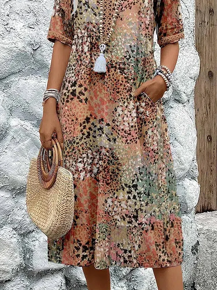 Detail view of patchwork print midi dress showing pocket and straw handbag