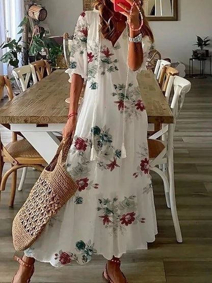 White floral-print maxi dress with red blooms and tasselled V-neck detail