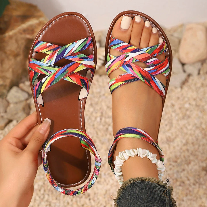 Multicoloured flat sandals with criss-cross straps styled with a shell anklet
