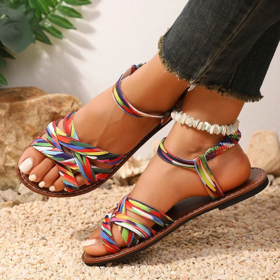 Close-up of multicoloured strappy flat sandals with woven ankle strap detail