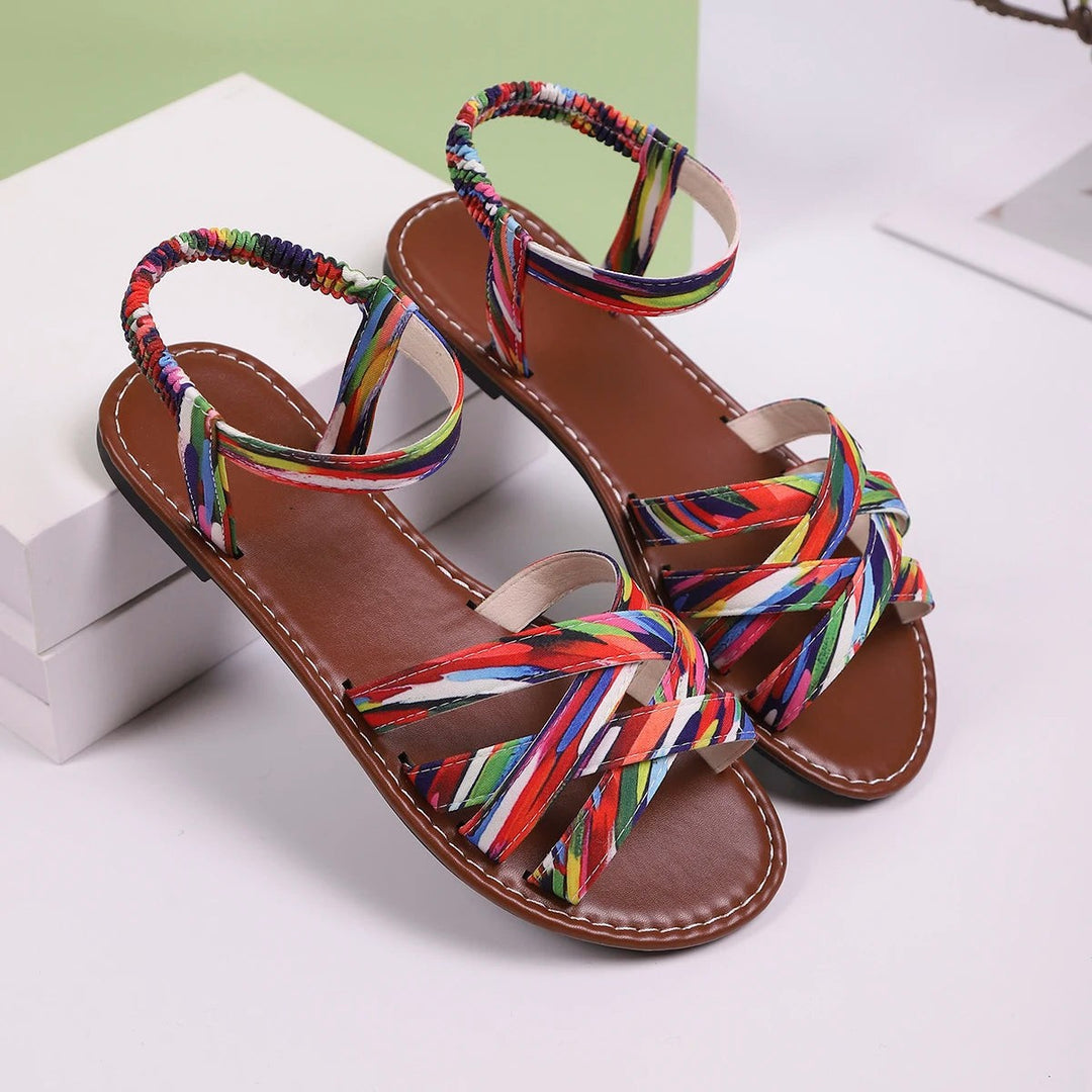 Pair of multicoloured criss-cross flat sandals with tan footbed on display