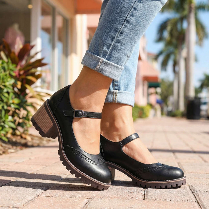 Black leather Mary Jane heels with brogue detailing and buckle ankle strap