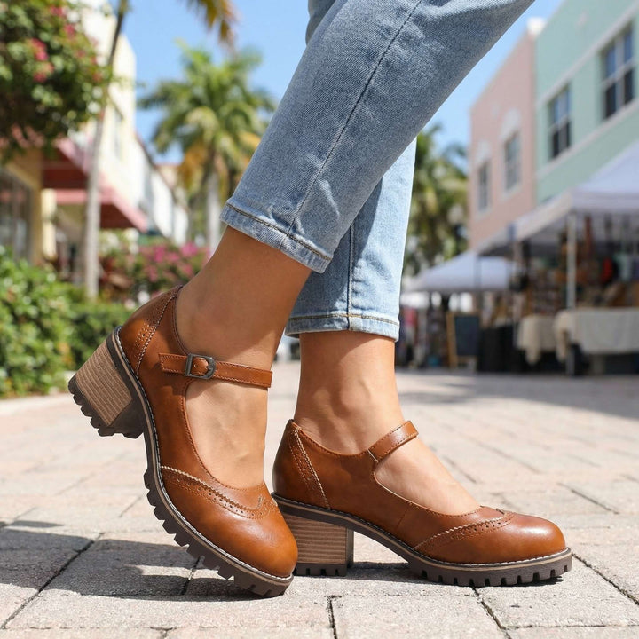 Tan brogue-style Mary Jane shoes with block heel and buckle strap