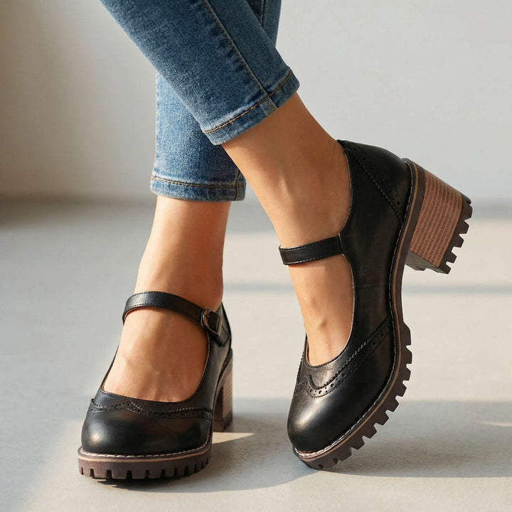 Black T-strap Mary Jane heels with brogue trim and lugged sole