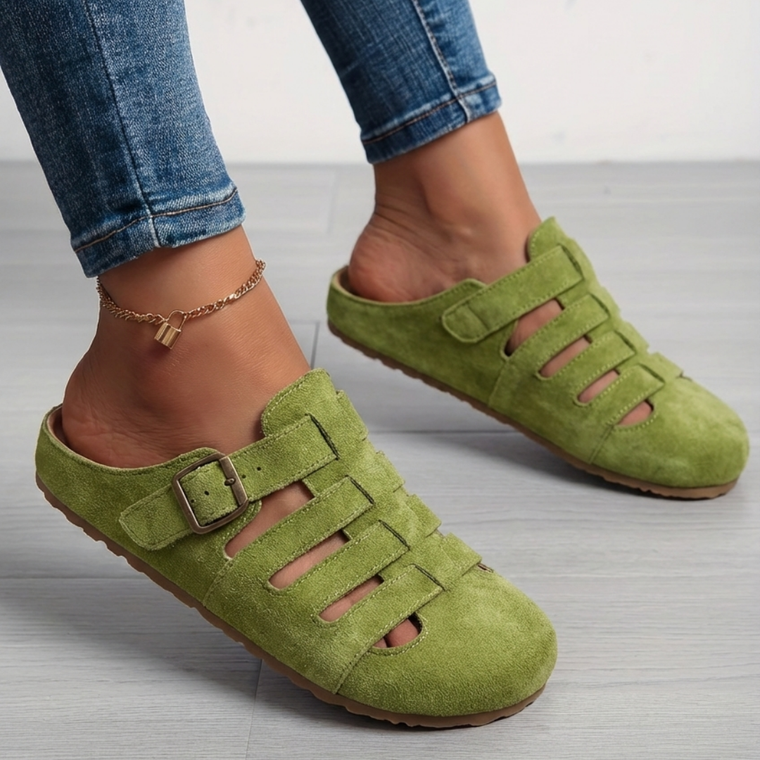 Green suede fisherman-style mule sandals with strappy cut-out design worn outdoors
