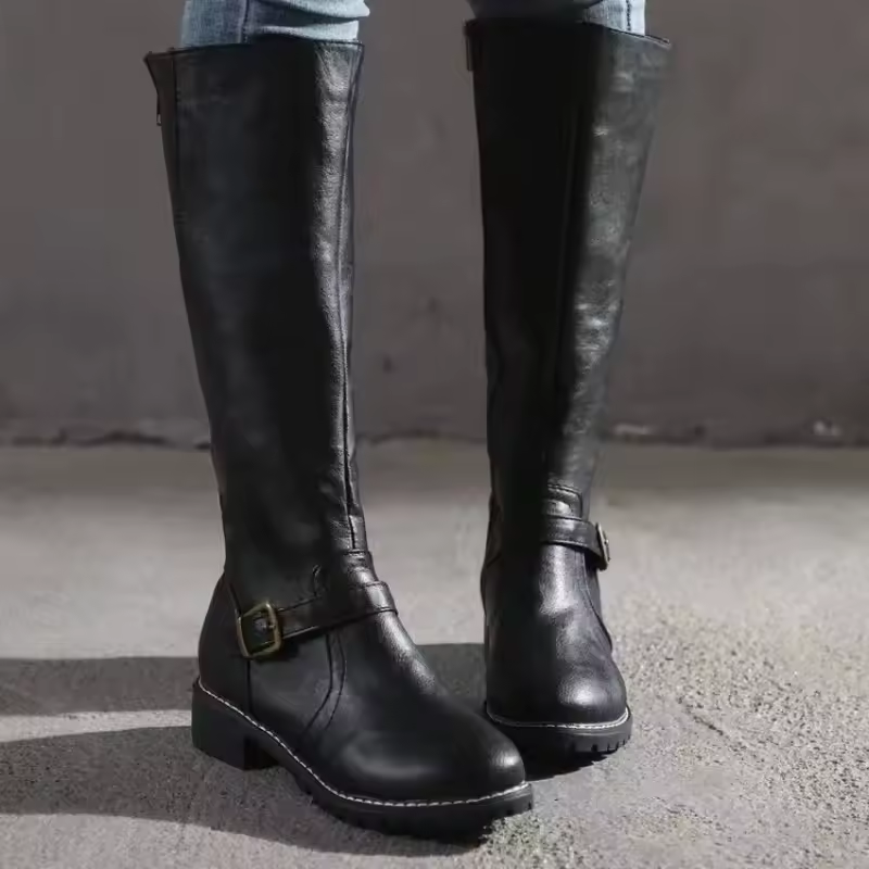 Front view of black leather knee-high boots with buckle and cleated sole