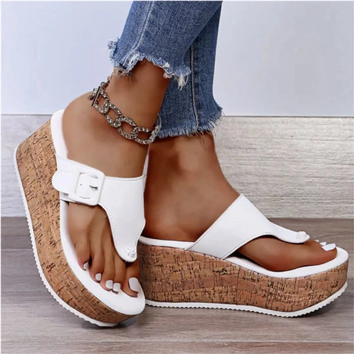White toe-post cork wedge sandals featuring buckle detail and platform sole