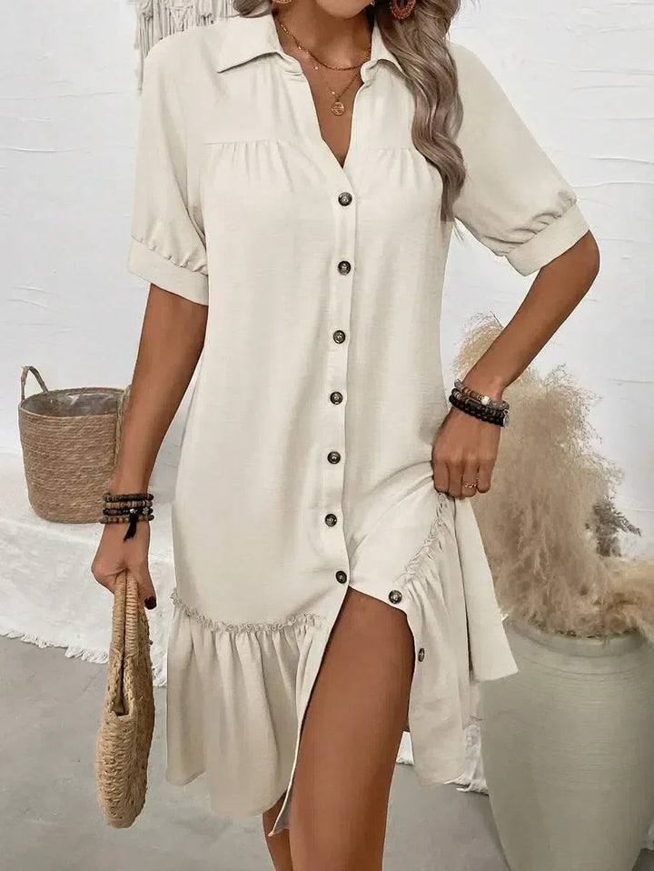 Close-up of beige shirt dress featuring button placket and frilled hem detail