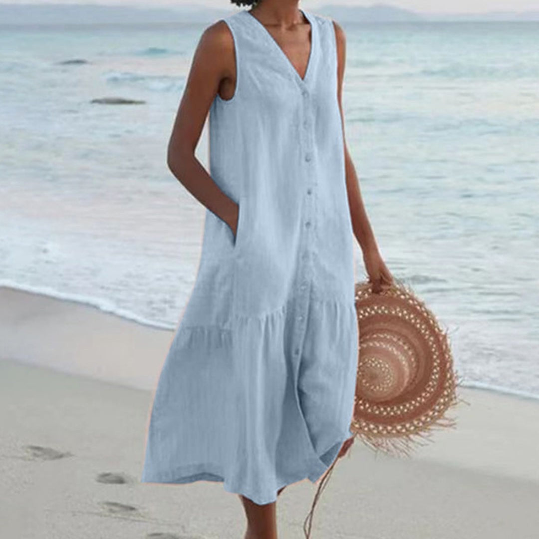 Pale blue linen sleeveless shirt dress with button-front detail on beach