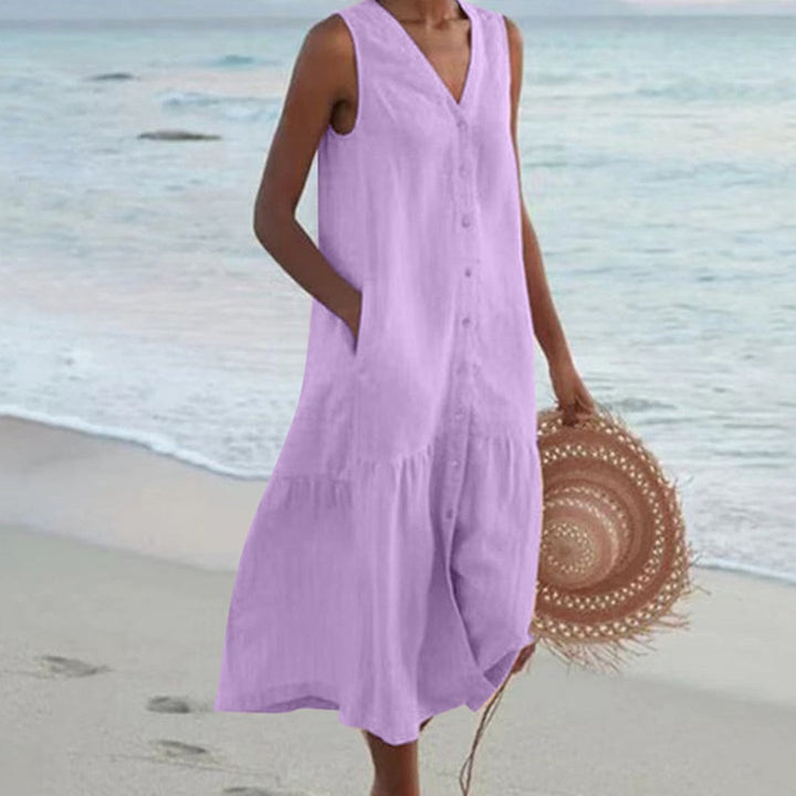 Lilac linen sleeveless midi shirt dress with V-neck, worn on sandy shore