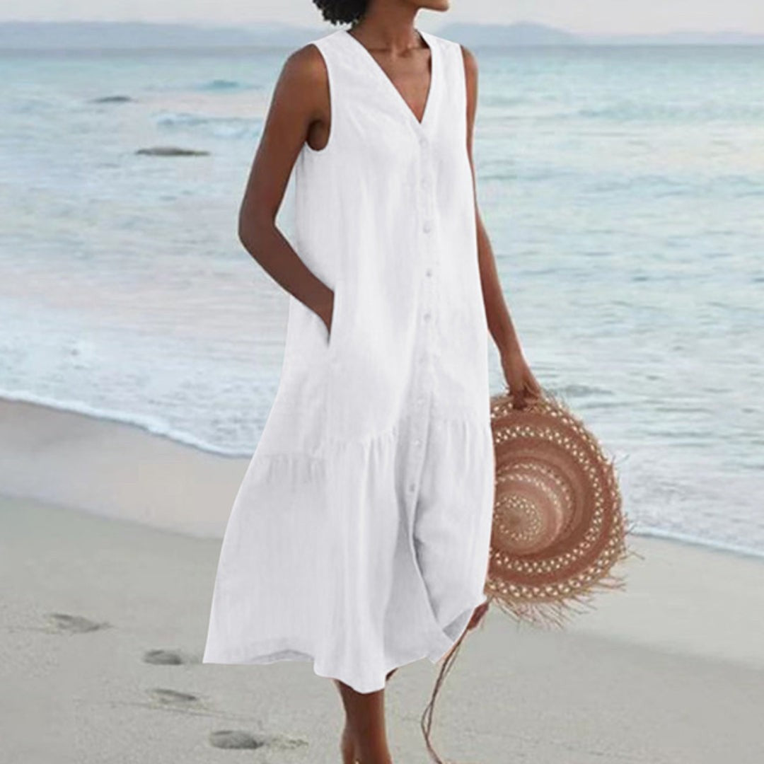White linen sleeveless midi shirt dress with tiered hem, styled for summer