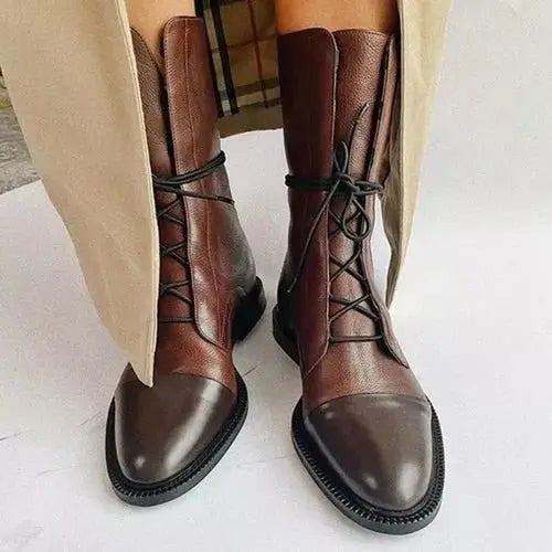 Brown leather lace-up ankle boots with contrast toe cap, styled with tailored trousers