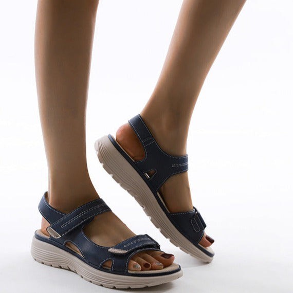 Side profile of navy sandals highlighting cut-out ankle strap design
